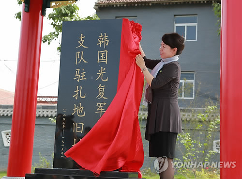 中國政府在西安韓國光復軍第二支隊駐地舊址設立的紀念碑29日上午10時正式揭幕，陜西省副省長王麗霞、韓國報勛處處長樸勝椿等共同出席了揭幕儀式。圖為王麗霞為紀念碑揭幕。(圖片來源：韓聯社)