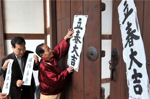 韓國民眾在傳統屋舍的大門上張貼“建陽多慶”“立春大吉”的對聯。