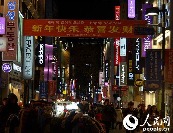 明洞街頭拉出寫有“新年快樂 恭喜發財”的條幅。（攝影：黃海燕）