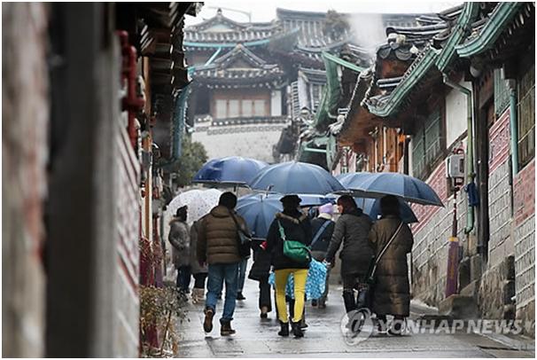  雨中的外國游客（圖片來源：韓聯社）
