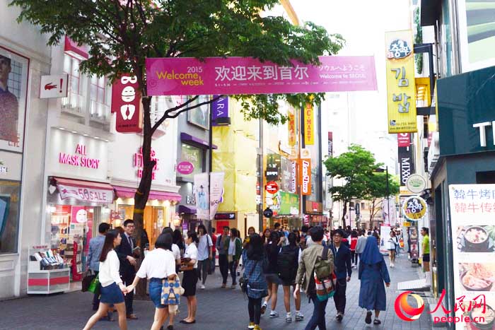 走入明洞主路，首先映入眼簾的便是這樣一條歡迎橫幅。（攝影：王昱祺）