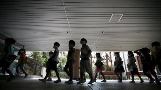 資料圖：韓國未停課的學校，學生課前戴口罩測體溫。（圖片來源：中新網）