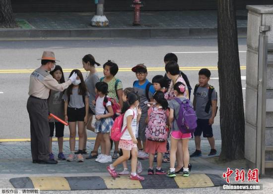 當地時間2015年6月17日，韓國首爾，小學生在排隊量體溫。