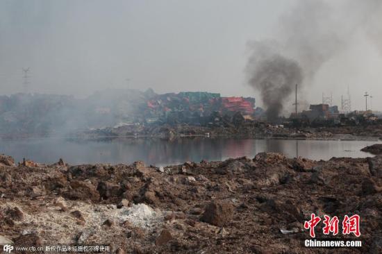天津濱?；瘜W品爆炸現場煙霧逐步散去，爆炸“原點”現出一個巨大的坑，坑內有大量液體，深度未明。圖片來源：CFP視覺中國