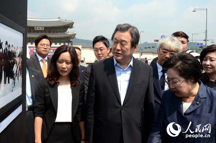 韓國執政黨新國家黨黨首金武星（中）、國會議員金乙東（右）、人民網韓國公司負責人周玉波（左）在觀看圖片展。（攝影：張悅）