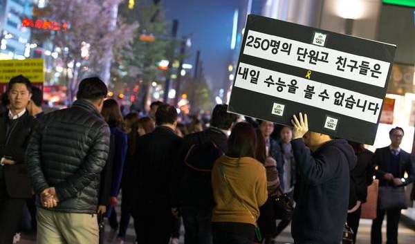韓國高考前一天，遇難學生家屬在江南站舉著“檀園高中的250個孩子明天不能參加高考了”的牌子。