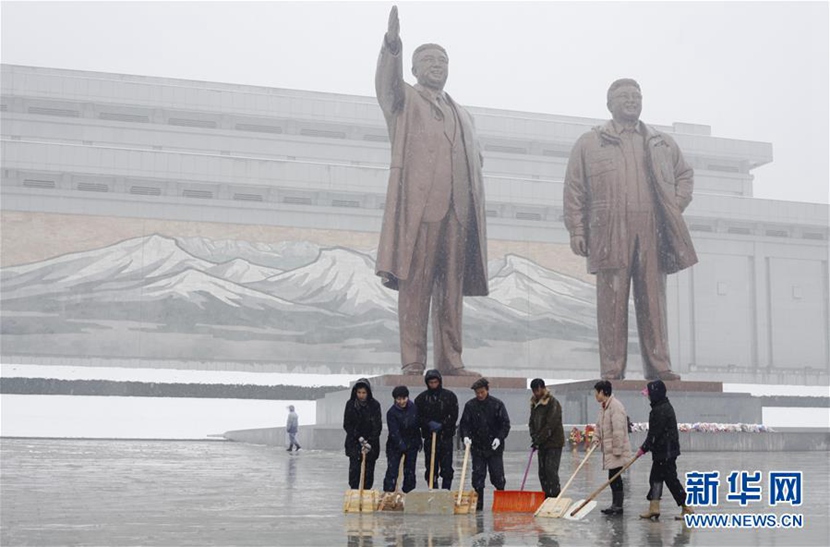11月25日，在朝鮮首都平壤，民眾在萬壽臺廣場清掃冰雪。 新華社記者朱龍川攝