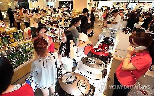 資料圖片：中國游客們在韓國免稅店選購電飯煲。
