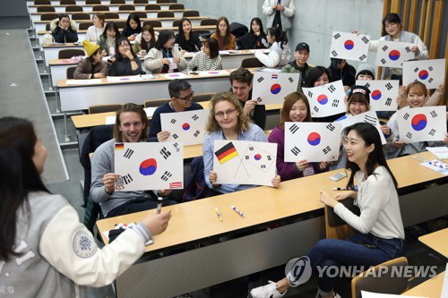 資料圖片：2月27日，在首爾明知大學人文校區，外國人留學生手繪韓國國旗。（韓聯社/明知大學供圖）