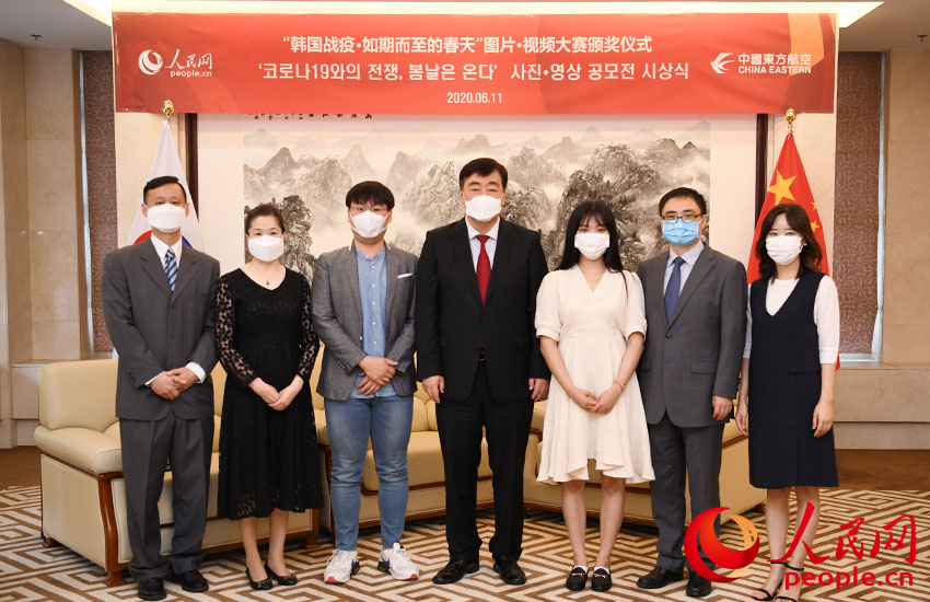“韓國戰疫·如期而至的春天”圖片·視頻大賽頒獎儀式在中國駐韓國大使館舉行。圖為中國駐韓國大使邢海明（中）與嘉賓、獲獎者代表合影留念。裴埈基攝