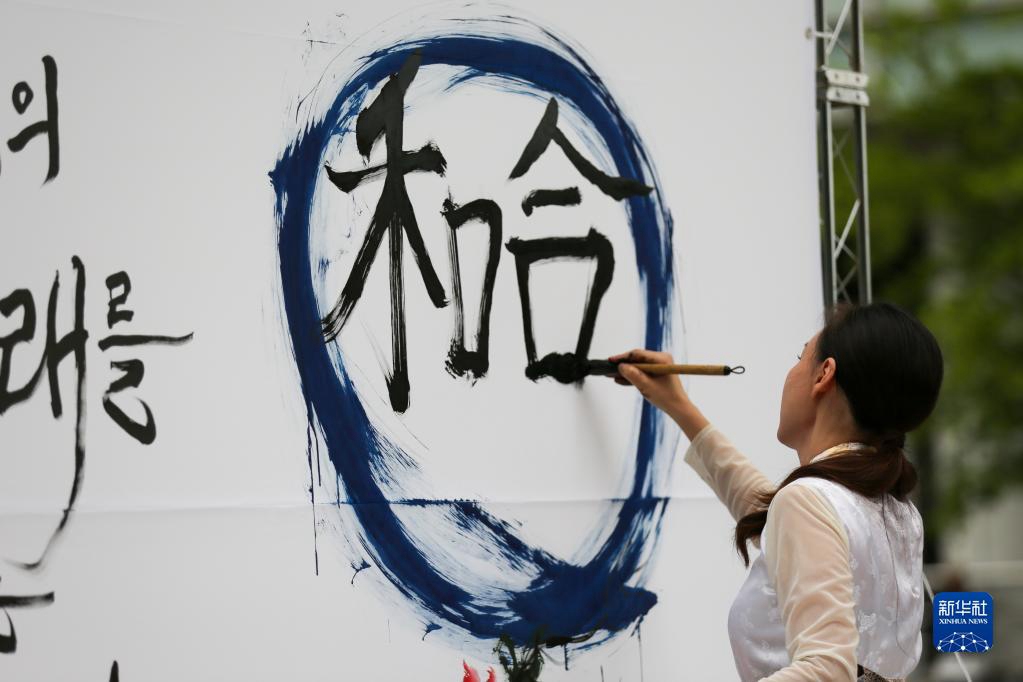 5月30日，在韓國首爾舉辦的“中日韓合作之日”慶?；顒又?，表演者進行中日韓精神——2023年度漢字“和合”書法表演。