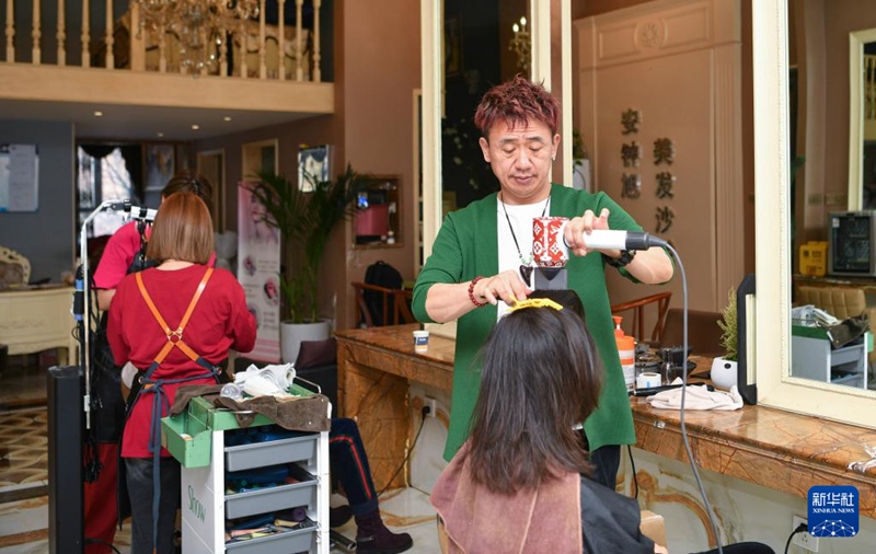 在位于烏魯木齊市城區的美發店，安鐘旭為一名顧客理發（3月15日攝）。