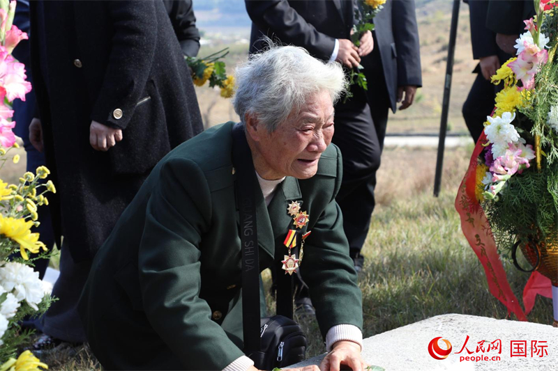 志愿軍特等功臣李家發的妹妹李家英向烈士墓祭酒獻花。 人民網記者 劉融攝