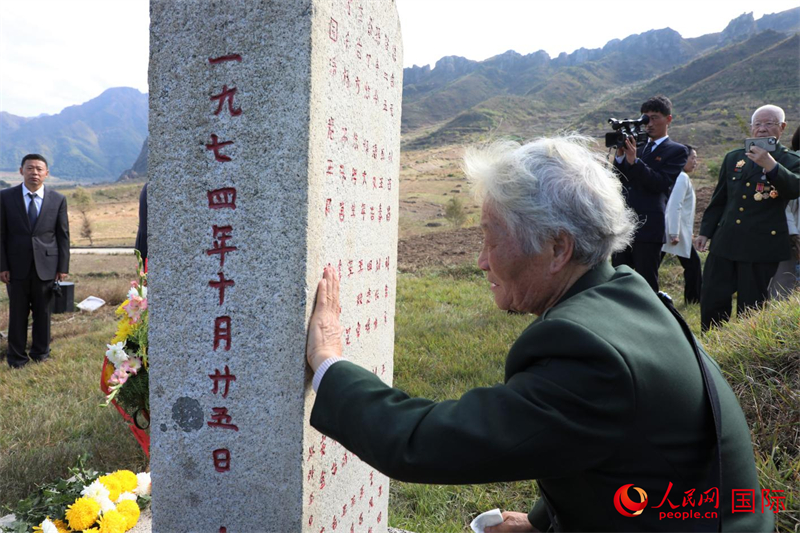 李家英老人撫摸、擦拭墓碑背后刻著的部分烈士姓名，深切緬懷志愿軍英烈們的豐功偉績。 人民網記者 劉融攝