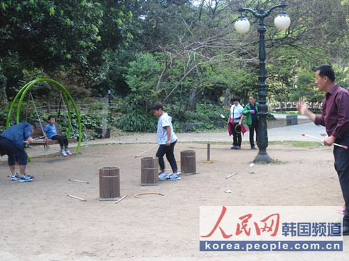 韓國傳統游戲之投壺圖片攝于濟州島天地淵瀑布景區內，游人在投壺
