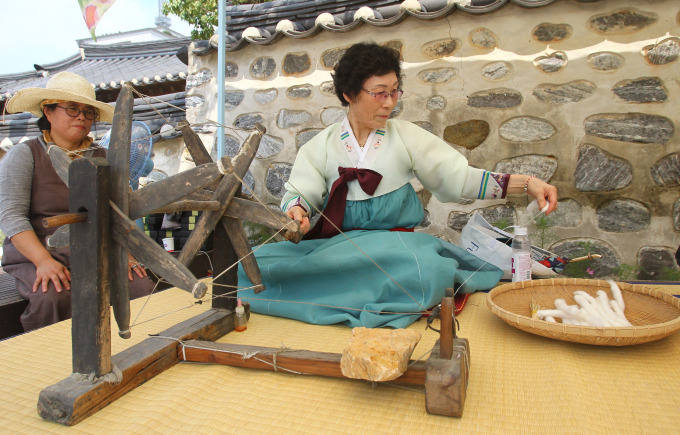 七夕節韓國舉辦民俗體驗活動圖為一名婦女在展示古時織布的過程圖片來源 新華社