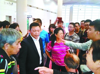 海南樂游國際旅行社有限公司鄭黎東（左二）被游客圍住指責