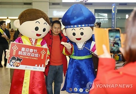 韓國觀光公社28日下午在仁川機場舉行歡迎中國游客的活動，身著韓國傳統服飾的公社職員正在與中國游客紀念合影。（韓聯社）